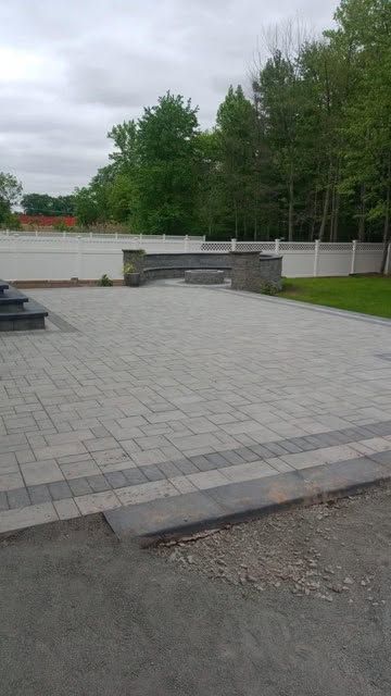 Herringbone paver patio with a built-in bench and pillar accents